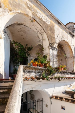 Un patio en el pueblo italiano de Albori. Escaleras al balcón con arcos