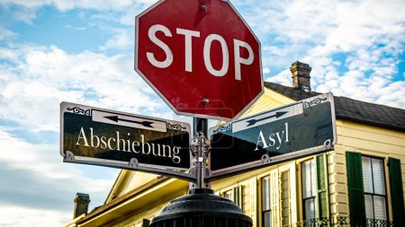 Photo for An image with a signpost pointing in two different directions in German. One direction points to asylum, the other points to deportation. - Royalty Free Image