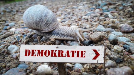 Téléchargez les photos : L'image montre un panneau indicateur et un signe qui pointe vers la démocratie en allemand. - en image libre de droit