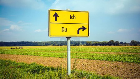 Foto de Una imagen con una señal apuntando en dos direcciones diferentes en alemán. Una dirección me apunta a mí, la otra a ti. - Imagen libre de derechos