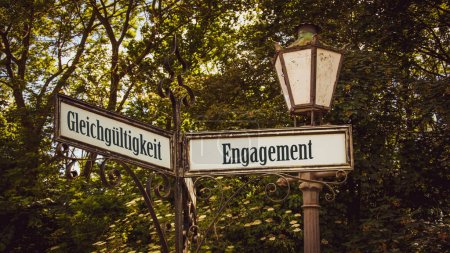 Photo for An image with a signpost pointing in two different directions in German. One direction points to commitment, the other points to indifference. - Royalty Free Image