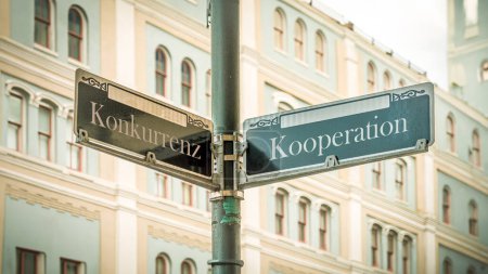 An image with a signpost pointing in two different directions in German. One direction points to cooperation, the other points to competition.