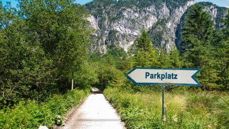 An image with a signpost in German pointing towards the parking lot.
