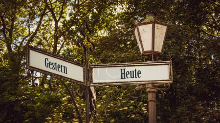 Téléchargez les photos : Une image avec un panneau pointant dans deux directions différentes en allemand. Une direction pointe vers aujourd'hui, l'autre vers hier. - en image libre de droit
