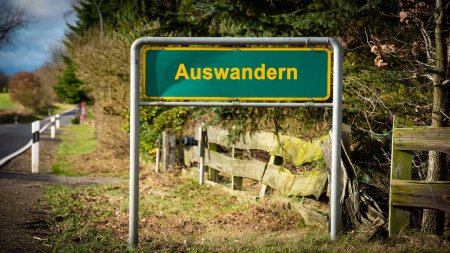 Image shows a signpost and a sign in the direction of emigration and wanderlust in German.