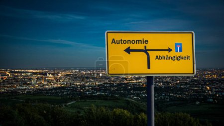 An image with a signpost pointing in two different directions in German. One direction points to autonomy, the other points to dependency.