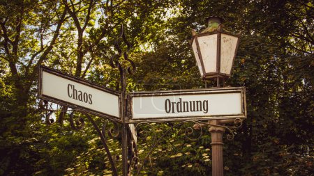 Téléchargez les photos : Une image avec un panneau pointant dans deux directions différentes en allemand. Une direction indique l'ordre, l'autre indique le chaos. - en image libre de droit