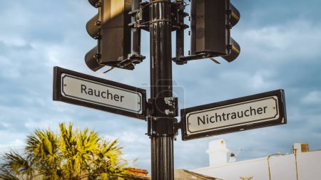 An image with a signpost pointing in two different directions in German. One direction points to non-smokers, the other points to smokers.