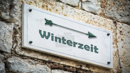 An image with a signpost in German pointing towards winter time.