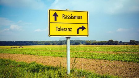 An image with a signpost pointing in two different directions in German. One direction points to racism, the other points to tolerance.
