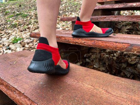 Photo for Walk. Red sneakers with black soles on the model's feet. Active lifestyle. Steps. - Royalty Free Image
