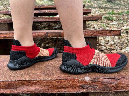 Photo for Walk. Red sneakers with black soles on the model's feet. Active lifestyle. Steps. - Royalty Free Image