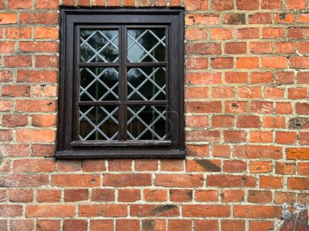 Ein schönes Fenster, ein Fragment einer Backsteinmauer einer alten Kirche.