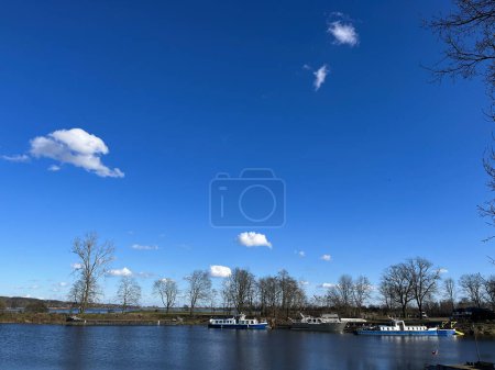 Schöne Frühlingslandschaft.Flussflut. Blauer Himmel. Spiegelungen im Wasser. Boote. 
