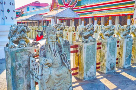Foto de Las esculturas de piedra de Singhas y Sabio chino rodean Ubosot, el templo principal del complejo Wat Arun en Bangkok, Tailandia - Imagen libre de derechos