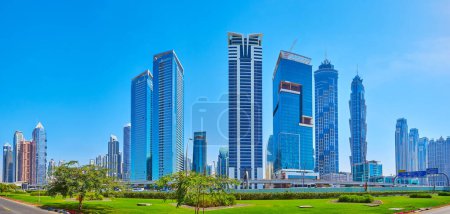 Téléchargez les photos : DUBAI, Émirats arabes unis - 6 mars 2020 : Panorama des lits de jardin de la route Cheikh Zayed à Business Bay avec des tours en verre en arrière-plan - Tiara United Towers, Single Business Tower, JW Marriot Marquis Towers, le 6 mars à Dubaï - en image libre de droit