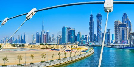 Téléchargez les photos : DUBAI, Émirats arabes unis - 6 MARS 2020 : Le paysage urbain avec des tours de verre futuristes, le canal d'eau de Dubaï et les câbles du pont Safa au premier plan, le 6 mars à Dubaï - en image libre de droit