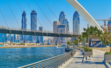 Téléchargez les photos : DUBAI, Émirats arabes unis - 6 MARS 2020 : La promenade pittoresque du canal d'eau de Dubaï avec vue sur les tours de verre modernes derrière le pont de la Tolérance, le 6 mars à Dubaï - en image libre de droit
