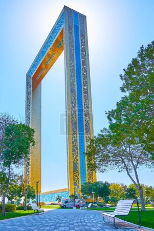 Photo for DUBAI, UAE - MARCH 6, 2020: The alley in Zabeel Park leads to the futuristic Dubai Frame, decorated with gilt ornaments, on March 6 in Dubai - Royalty Free Image