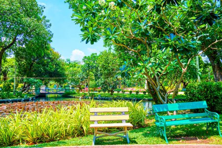 Téléchargez les photos : Bancs colorés à l'étang dans les environs de la verdure de Saranrom Palace Park, Bangkok, Thaïlande - en image libre de droit