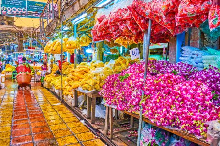 Foto de BANGKOK, TAILANDIA - 23 DE ABRIL DE 2019: Los montones de flores de caléndulas y orquídeas en las mesas en el mercado de flores Pak Khlong Talat, el 23 de abril en Bangkok, Tailandia - Imagen libre de derechos