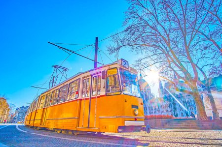 Classic retro styled tram rides at Parliament building in city center of Budapest, Hungary