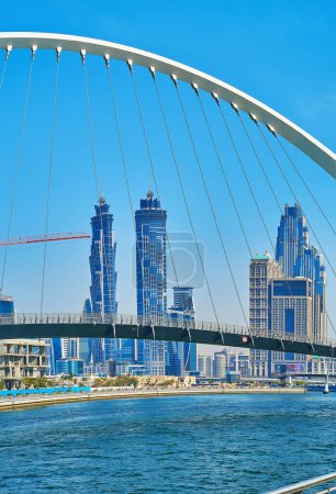 Téléchargez les photos : DUBAI, Émirats arabes unis - 6 MARS 2020 : Canal d'eau de Dubaï avec pont de tolérance piétonne moderne et horizon urbain futuriste en arrière-plan, le 6 mars à Dubaï - en image libre de droit