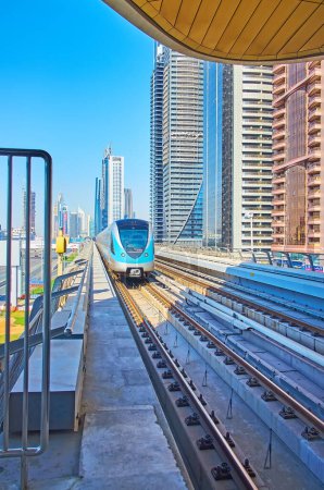 Téléchargez les photos : DUBAI, Émirats arabes unis - 6 MARS 2020 : Le train de la ligne rouge du métro de Dubaï, qui longe les tours futuristes, le 6 mars à Dubaï - en image libre de droit