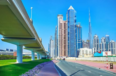 Téléchargez les photos : DUBAI, Emirats Arabes Unis - 6 MARS 2020 : Le passage supérieur du métro de Dubaï et les tours futuristes de Business Bay et Downtown contre le ciel bleu vif, le 6 mars à Dubaï - en image libre de droit