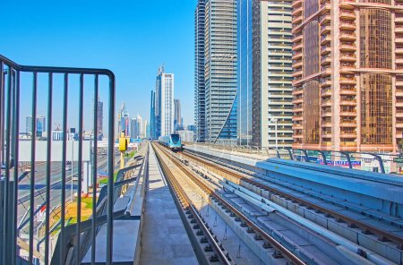Téléchargez les photos : DUBAI, Émirats arabes unis - 6 MARS 2020 : Le chemin de fer de la ligne rouge du métro de Dubaï sur la station de métro Business Bay avec vue sur les gratte-ciel futuristes, le 6 mars à Dubaï - en image libre de droit