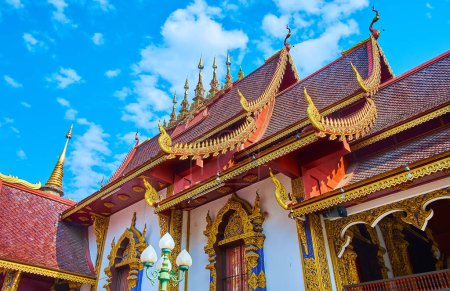 Téléchargez les photos : Les barges dorées sculptées, les chofas sculptés et les parapluies hti sur le toit en tuiles rouges du Viharn dans le temple Wat Saen Muang Ma, Chiang Mai, Thaïlande - en image libre de droit