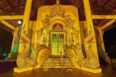 Photo for The entrance gate of Phra Viharn Luang of Wat Chedi Luang, decorated with moulding, statues of Naga serpents, gilt images of Devata deities on doors, Chiang Mai, Thailand - Royalty Free Image