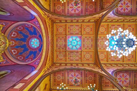 Foto de BUDAPEST, HUNGRÍA - 22 DE FEB DE 2022: La sinagoga de Dohany Street cuenta con un techo ricamente decorado con patrones gamma ocres, tallas y candelabros de cristal, el 22 de febrero en Budapest - Imagen libre de derechos