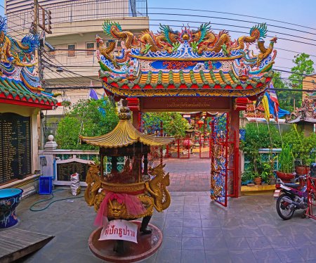 Foto de The richly decorated sculptured paifang gate of Pung Thao Kong Shrine with dragon sculptures and seeping roof, Chiang Mai, Thailand - Imagen libre de derechos