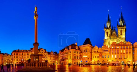 Foto de PRAGUE, CZECHIA - MARCH 11, 2022: Panorama of Old Town Square with Marian Columna and towers of Tyn chuach in night illumination, on March 11 in Prague, Czechia - Imagen libre de derechos