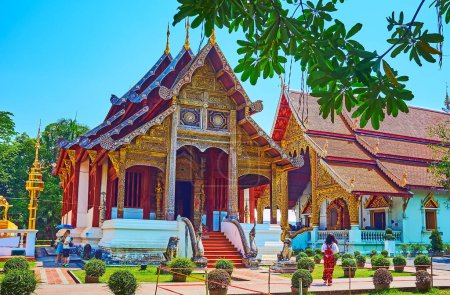 Téléchargez les photos : The medieval Phra Uposatha (Ubosot) of Wat Phra Singh, decorated with gilt patterns, wooden carvings, pyathat roof and sculptures of Naga serpents, Chiang Mai, Thailand - en image libre de droit