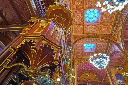 Téléchargez les photos : BUDAPEST, HUNGARY - FEB 22, 2022: Dohany Street Synagogue prayer hall with carved wooden pulpit and richly decorated ceiling, on Feb 22 in Budapest - en image libre de droit