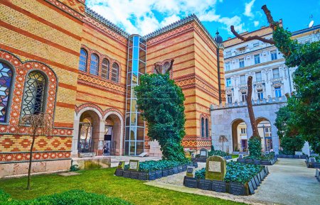 Téléchargez les photos : The green courtyard of Dohany Street Synagogue with cemetery and old tall trees, Budapest, Hungary - en image libre de droit