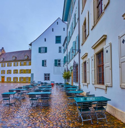 Foto de Empty cafe on Munsterplatz (Minster Cathedral square) on a rainy day, Basel, Switzerland - Imagen libre de derechos