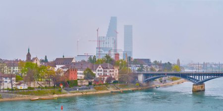 Téléchargez les photos : Rhine river in Basel with traditional residential houses on the riverbank and modern business buildings on background, Switzerland - en image libre de droit