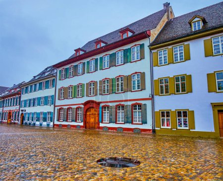 Foto de Minster Cathedral square with traditional houses and cast iron plate on the pavement marking the ancient Roman Well in Basel, Switzerland - Imagen libre de derechos
