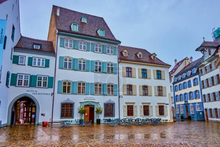 Téléchargez les photos : BASEL, SWITZERLAND - APRIL 1, 2022: Rainy day with empty outdoor cafe on Minster Cathedral square, on April 1 in Basel, Switzerland - en image libre de droit