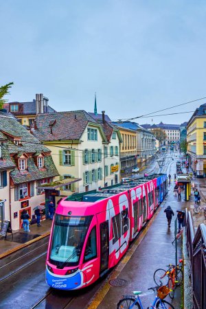 Foto de BASEL, SWITZERLAND - APRIL 1, 2022: The colorful modern tram on Kohlenberg street in Old town, on April 1 in Basel, Switzerland - Imagen libre de derechos