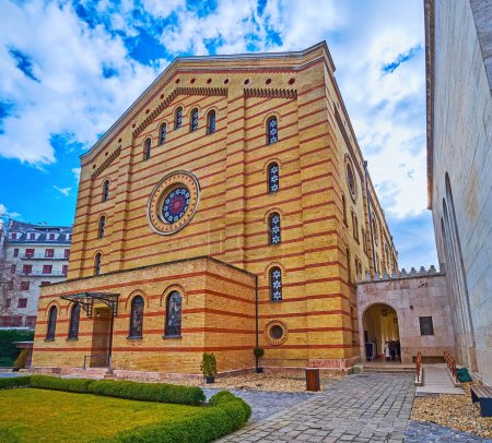 Foto de Edificio histórico de la sinagoga de Dohany Street con pared de ladrillo, decorado con rayas de diferentes colores y vidrieras, Budapest, Hungría - Imagen libre de derechos