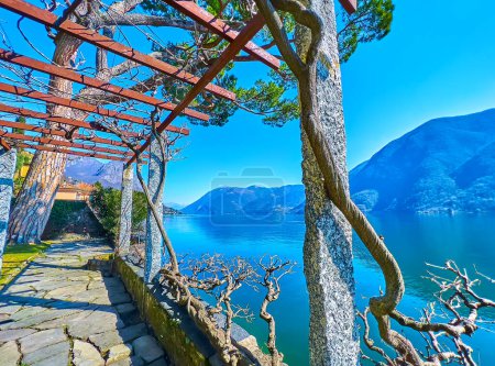 The beautiful garden with stone pergola on Lake Lugano embankment, Oria, Valsolda, Lombardy, Italy