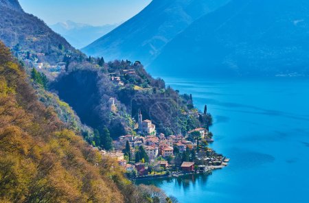 Maisons colorées de San Mamete et l'église médiévale au pied de la montagne sur la rive du lac de Lugano, Valsolda, Suisse