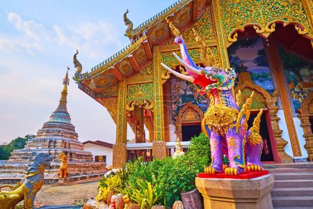 Photo for The sculptured Chedi, ornate Viharn and colored Hatsadiling (winged elephant) statue in the foreground, Wat Chetawan, Chiang Mai, Thailand - Royalty Free Image