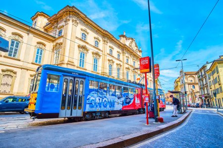 Photo for MILAN, ITALY - APRIL 11, 2022: Colorful tram on the tram stop on Corso Magenta street, on April 11 in Milan, Italy - Royalty Free Image