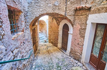 Photo for Walk down the medieval stone descent with an arched pass under the vintage living house in Albogasio, Valsolda, Italy - Royalty Free Image
