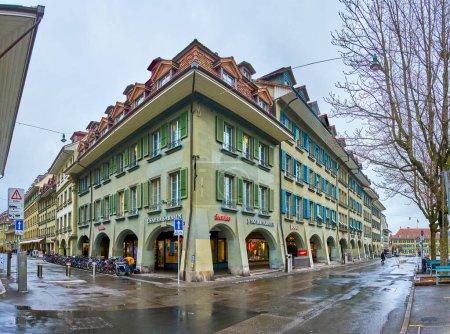 Foto de BERN, SUIZA - 31 DE MARZO DE 2022: La casa de esquina con arcadas típicas bernesas a pie en Waisenhausplatz y Neuengasse, el 31 de marzo en Berna, Suiza - Imagen libre de derechos